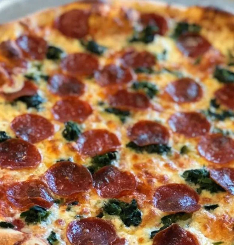 Close-up of a fresh pepperoni and spinach pizza