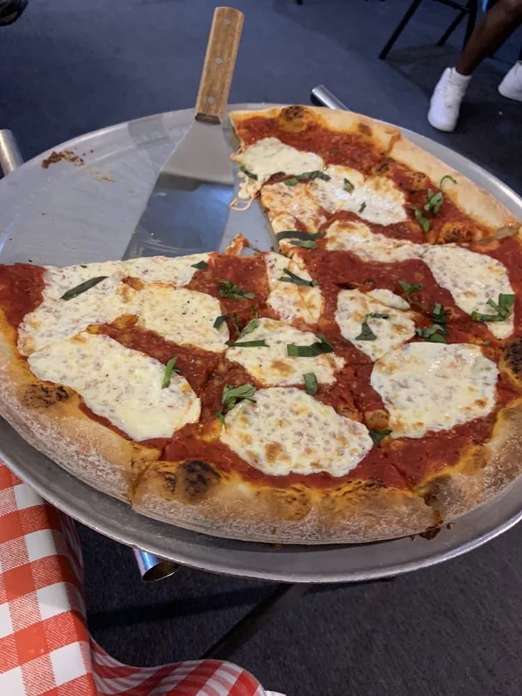 Fresh brick oven pizza being served on the patio